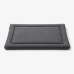 Dog resting calmly on a settle mat during owner work time